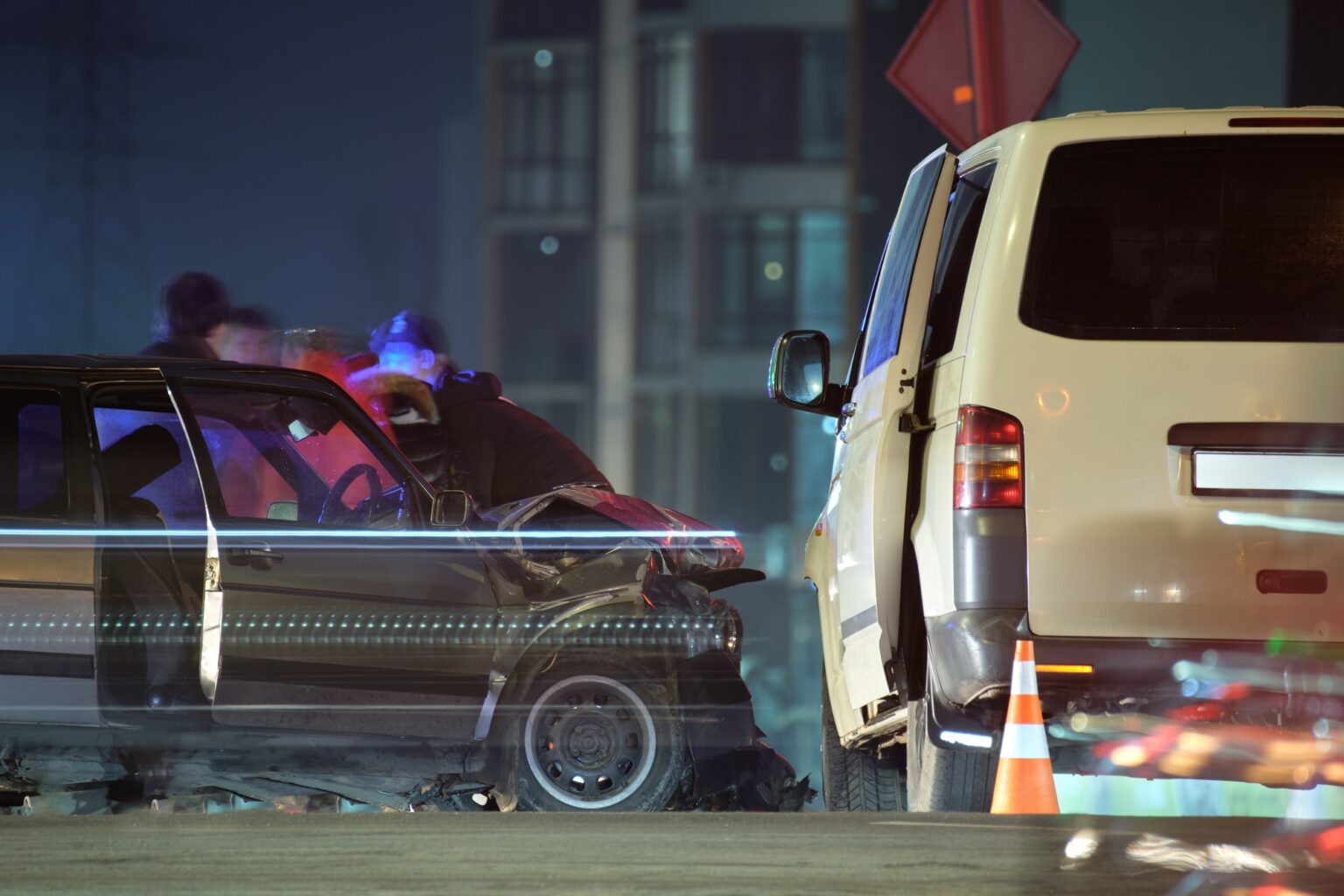 Damaged in heavy car accident vehicles after collision on city street crash site and silhouette of